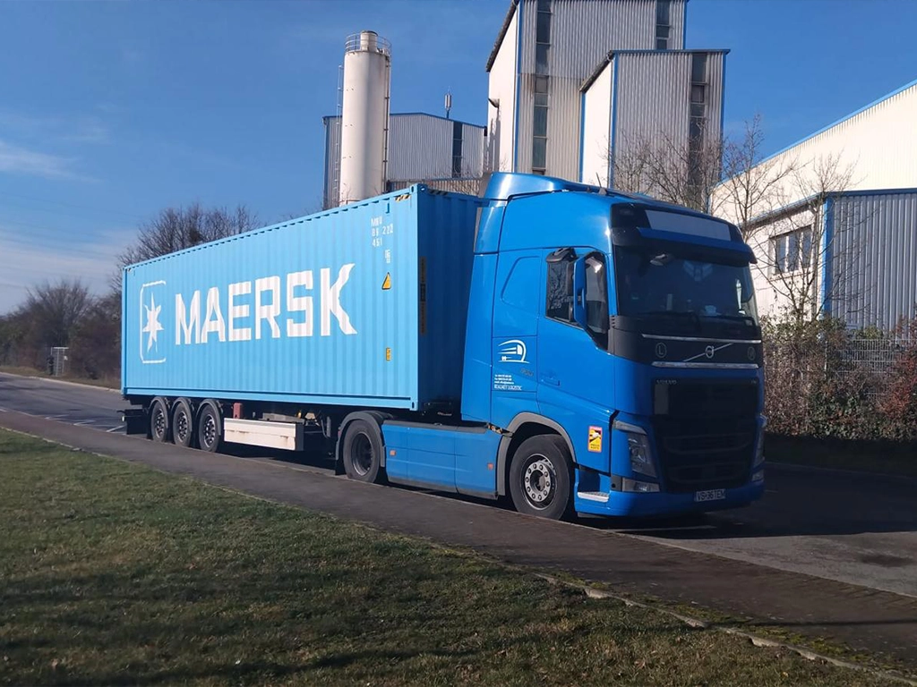 Ansamblu cap tractor Volvo si semiremorca ce transporta un container maritim