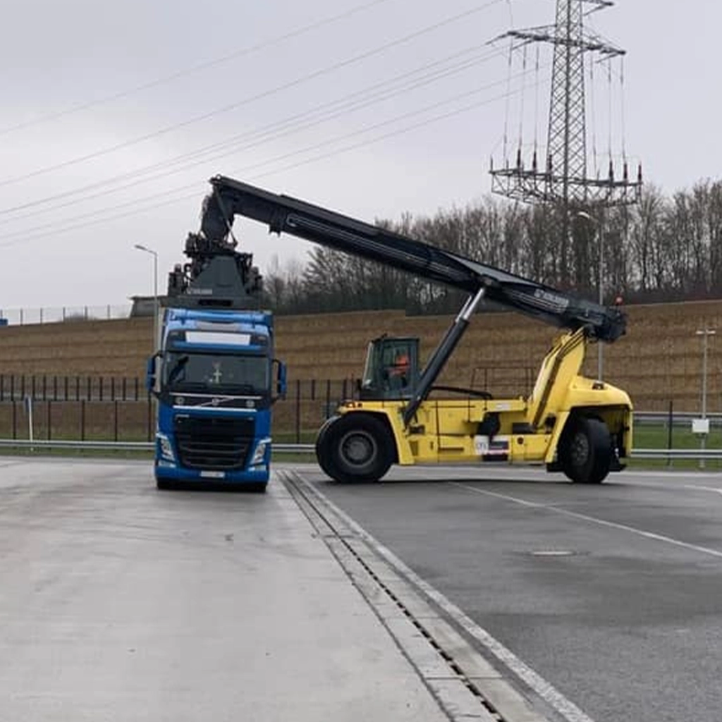 Ansablu de transport din flota Realmet si un utilaj ce preia de pe semiremorca un container maritim