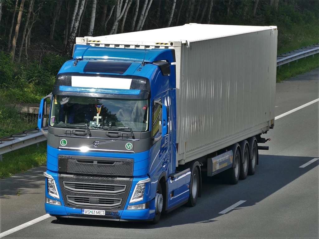 Camion Volvo si semiremorca cu container maritim fotografiat pe autostrada